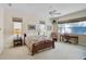 Bright bedroom with ceiling fan, two windows, desk and chair at 901 Reflection Way, Osprey, FL 34229