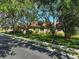 Street view of home with mature trees, green lawn, and manicured landscaping at 901 Reflection Way, Osprey, FL 34229