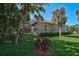 Exterior side view of home showing the screened patio and backyard with lush landscaping at 901 Reflection Way, Osprey, FL 34229