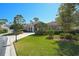 Home featuring a well-maintained lawn, mature trees, and attractive curb appeal at 901 Reflection Way, Osprey, FL 34229