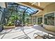 Relaxing screened-in patio with lush landscaping and a water fountain at 901 Reflection Way, Osprey, FL 34229