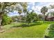 Landscaped backyard with a pond and lush trees with a black chain-link fence at 919 80Th Nw St, Bradenton, FL 34209