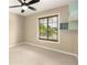 Comfortable bedroom featuring a large window, a modern ceiling fan, and a built-in shelf, offering both style and convenience at 919 80Th Nw St, Bradenton, FL 34209
