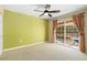 Bedroom featuring natural light from a sliding glass door leading to an outdoor patio, with ceiling fan and neutral colors at 919 80Th Nw St, Bradenton, FL 34209