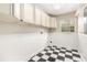 Laundry room featuring checkered floors, white cabinets, wainscotting and a window at 919 80Th Nw St, Bradenton, FL 34209