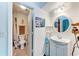Bright bathroom features a single sink vanity with a round mirror and adjacent toilet at 1026 Longfellow Ct # 111, Sarasota, FL 34243