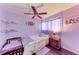 This purple bedroom features a floral bed set, matching nightstand, and a dark wood floor at 1026 Longfellow Ct # 111, Sarasota, FL 34243