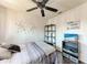 This cozy bedroom features a ceiling fan, dark wood floors, and modern shelving for storage at 1026 Longfellow Ct # 111, Sarasota, FL 34243