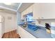 Efficient kitchen featuring white cabinets, a double sink, and an opening to the living area at 1026 Longfellow Ct # 111, Sarasota, FL 34243