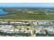 Expansive aerial view of waterfront properties featuring private boat docks, lush greenery, and blue ocean view at 10304 Sandpiper W Rd, Bradenton, FL 34209