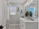 Stylish bathroom with double vanity and framed art above the tub at 10304 Sandpiper W Rd, Bradenton, FL 34209
