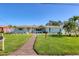 Inviting single-story home featuring a lush green lawn, decorative shutters, and mature landscaping at 10304 Sandpiper W Rd, Bradenton, FL 34209