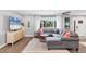 Cozy living room features a large grey sectional sofa and a modern entertainment center with a surfboard at 10304 Sandpiper W Rd, Bradenton, FL 34209