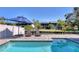 Stylish pool area with lounge chairs, umbrella and views of a canal, great for outdoor relaxation at 10304 Sandpiper W Rd, Bradenton, FL 34209