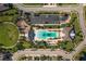Aerial view of community pool and playground area with lush landscaping, parking lot, and sidewalks at 11925 Brookside Dr, Bradenton, FL 34211