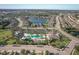 Community aerial view featuring the pool, playground, and nearby neighborhoods with a lake at 11925 Brookside Dr, Bradenton, FL 34211