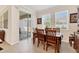 Bright dining area with wood table set, tile floors, slider to screened patio, and natural light at 11925 Brookside Dr, Bradenton, FL 34211