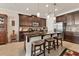 Spacious kitchen featuring dark wood cabinetry, granite countertops, mosaic backsplash, an island with seating, and stainless appliances at 11925 Brookside Dr, Bradenton, FL 34211