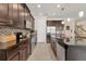 Modern kitchen with dark wood cabinets, stainless steel appliances, mosaic backsplash, and an island with granite countertop at 11925 Brookside Dr, Bradenton, FL 34211