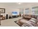 Comfortable living room featuring neutral walls, tile flooring, and natural light from the windows at 11925 Brookside Dr, Bradenton, FL 34211