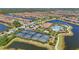 Aerial view of a community with a lake, clubhouse, pool, and tennis courts, offering diverse amenities at 12020 Legacy Estates Blvd, Sarasota, FL 34238