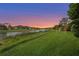 Manicured backyard overlooking a serene lake, ideal for enjoying peaceful sunsets at 12020 Legacy Estates Blvd, Sarasota, FL 34238