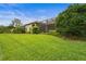 Expansive backyard with lush landscaping and a screened-in patio overlooking the lawn at 12020 Legacy Estates Blvd, Sarasota, FL 34238