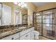Well-lit bathroom features a marble counter, a sink, and a glass-enclosed shower with brown tiling at 12020 Legacy Estates Blvd, Sarasota, FL 34238
