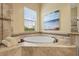 A soaking tub with tile surround is next to a window and glass shower in the Primary bathroom at 12020 Legacy Estates Blvd, Sarasota, FL 34238