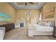 A bright, carpeted bedroom includes seating, modern storage, a ceiling fan, and an ensuite bathroom at 12020 Legacy Estates Blvd, Sarasota, FL 34238