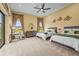 Spacious bedroom features two beds, a ceiling fan, and large windows overlooking the lawn at 12020 Legacy Estates Blvd, Sarasota, FL 34238