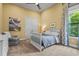 Bright bedroom features a ceiling fan, closet, crib, and large window with tree views at 12020 Legacy Estates Blvd, Sarasota, FL 34238