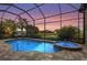 Screened-in pool and spa with a beautiful sunset view over the water at 12020 Legacy Estates Blvd, Sarasota, FL 34238