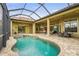 Enclosed pool area with landscaping has seating and dining areas overlooking the lawn and lake at 12020 Legacy Estates Blvd, Sarasota, FL 34238
