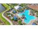 Aerial view of a community pool area featuring a hot tub, sun loungers, and beautifully landscaped surroundings at 12020 Legacy Estates Blvd, Sarasota, FL 34238