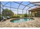 Enclosed pool area with chairs and landscaping overlooks the lawn, lake, and other houses at 12020 Legacy Estates Blvd, Sarasota, FL 34238