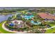 Aerial view of a community pool area with a water park and lounging areas near a lake at 12020 Legacy Estates Blvd, Sarasota, FL 34238