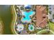 Aerial view of a community pool and waterpark area with lush landscaping and lounge chairs at 12020 Legacy Estates Blvd, Sarasota, FL 34238