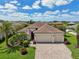 Stunning aerial view of the home highlighting a three-car garage, manicured lawn, and brick driveway at 12210 Goldenrod Ave, Bradenton, FL 34212