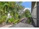 Paver path through the backyard's landscaping with tropical plants, foliage, and decorative pots at 12210 Goldenrod Ave, Bradenton, FL 34212