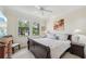 Bedroom with natural light, neutral walls, ceiling fan, and a view to the palm trees outside at 12210 Goldenrod Ave, Bradenton, FL 34212