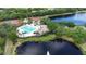 Aerial view of community pool, playground, tennis courts, and beautiful landscaping around a tranquil lake at 12210 Goldenrod Ave, Bradenton, FL 34212