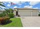 Charming single-story home with a well-manicured lawn, a two-car garage, and an American flag at 12210 Goldenrod Ave, Bradenton, FL 34212