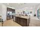 Open kitchen with granite island, stainless appliances, and adjacent dining and living areas at 12210 Goldenrod Ave, Bradenton, FL 34212