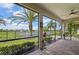 Relaxing screened patio overlooking backyard and pond with tropical landscaping and mature trees at 12210 Goldenrod Ave, Bradenton, FL 34212