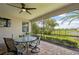 Screened patio area with outdoor dining furniture, ceiling fan, overlooking backyard and pond at 12210 Goldenrod Ave, Bradenton, FL 34212
