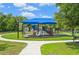 Community playground with shade structure, slides, and play equipment on a sunny day at 12210 Goldenrod Ave, Bradenton, FL 34212