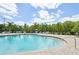 Relaxing community pool area with lounge seating and lush landscaping in a tropical setting at 12210 Goldenrod Ave, Bradenton, FL 34212