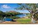 Backyard featuring a dock, boat storage, water access, lush trees and a bench at 1479 Bay Point Dr, Sarasota, FL 34236