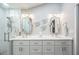 Modern bathroom featuring double sinks, stylish mirrors, and a walk-in glass shower with tiled walls at 1490 Mahogany Ln # 706, Palm Harbor, FL 34683
